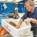 Fishmonger packing up his fish